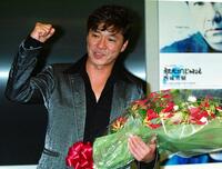 　花束を手に笑顔でガッツポーズの西城秀樹さん＝２００３年