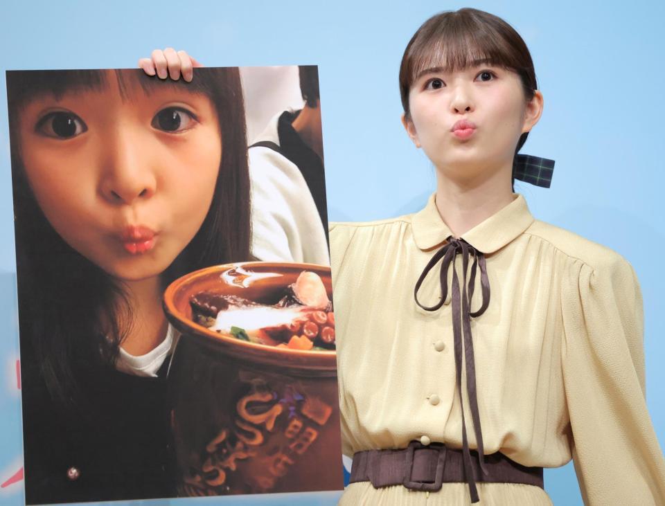 　子どもの時に食べた駅弁の写真を手にタコポーズをする小川彩（撮影・吉澤敬太）