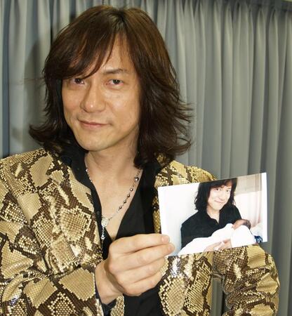 　愛娘とのツーショット写真をかざすダイアモンド☆ユカイ＝２０１０年