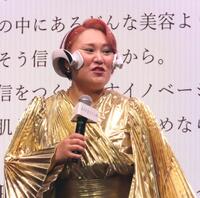 　クイックフェイシャルトレーナーを着用しマイクを握るバービー