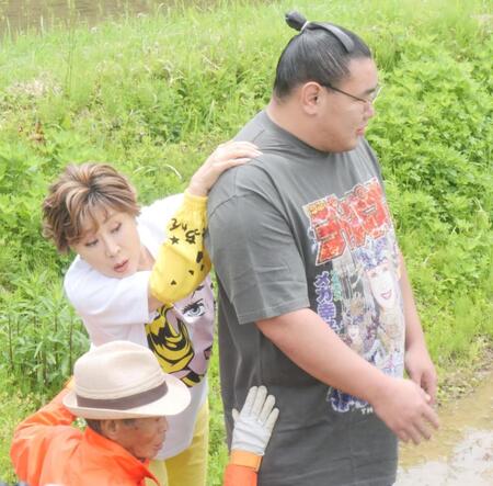 　田んぼまで豊昇龍（右）の大きな背に手を置き歩く小林幸子