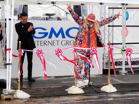 　ダブルピースを出すＤＪ　ＫＯＯ（右）と拍手を送る瀧藤雅朝・日本音楽事業者協会会長