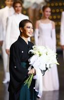 　花束を手に笑顔を見せる礼真琴