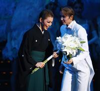 　次期トップの暁千星（右）から花束を受け取る礼真琴