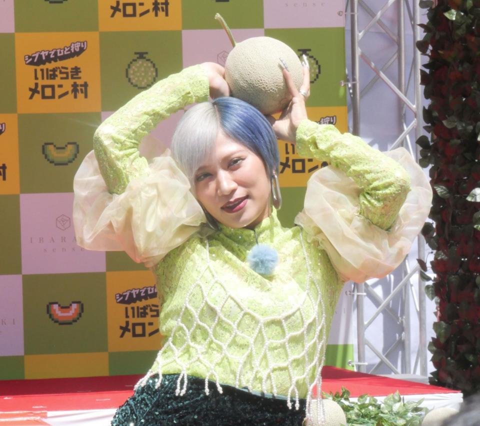 　メロンを手に決めポーズを取る信子