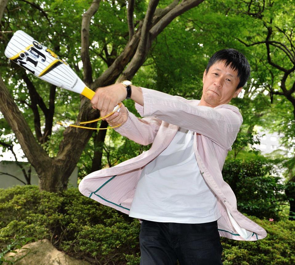 　掛布雅之氏の打撃フォームをまね、勢いよくメガホンを振る山田雅人＝２０１４年