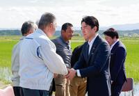 　福島県南相馬市でコメ生産者らと意見交換し、握手する小泉農相（手前右）＝１５日
