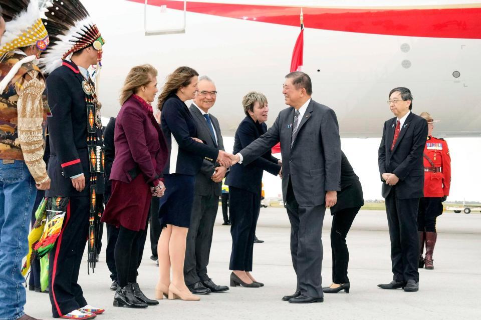 　Ｇ７サミット出席のため、カナダのカルガリー国際空港に到着し、出迎えを受ける石破首相（中央右）＝共同