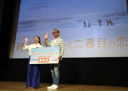 　海岸の映像を背に手を振る小泉今日子（左）と中井貴一（撮影・西岡正）