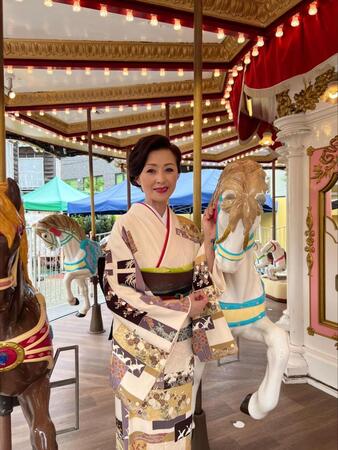 　浅草花やしきのメリーゴーランドで笑顔を浮かべる長山洋子