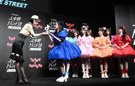 　プレゼンターのあのちゃん（左）からトロフィーを渡されるＣＵＴＩＥ　ＳＴＲＥＥＴのメンバーたち（撮影・園田高夫）