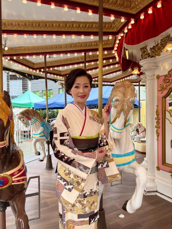　浅草花やしきのメリーゴーランドで笑顔を浮かべる長山洋子