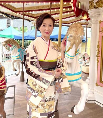 　浅草花やしきのメリーゴーランドで笑顔を見せる長山洋子