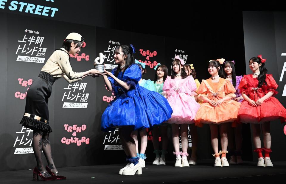 　プレゼンターのあのちゃん（左）からトロフィーを渡されるＣＵＴＩＥ　ＳＴＲＥＥＴのメンバーたち（撮影・園田高夫）