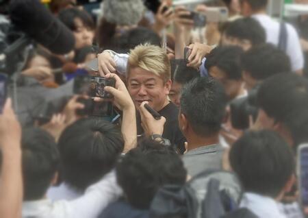 　報道陣に囲まれる堀江貴文氏（中央）＝２５日