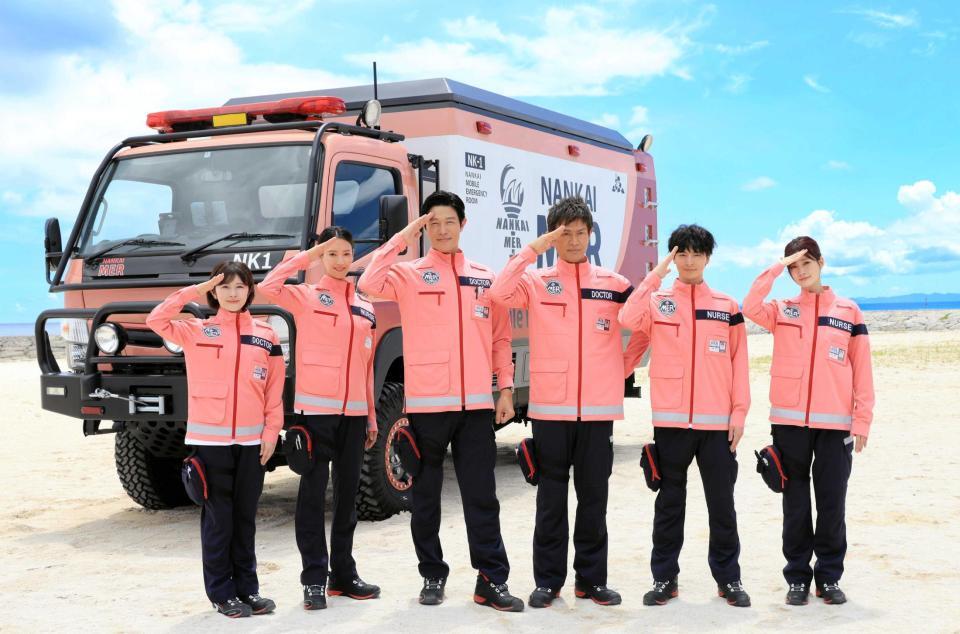 　ＥＲカーをバッグに敬礼する（左から）宮澤エマ、菜々緒、鈴木亮平、江口洋介、高杉真宙、生見愛瑠　©２０２５　劇場版『ＴＯＫＹＯ　ＭＥＲ』製作委員会