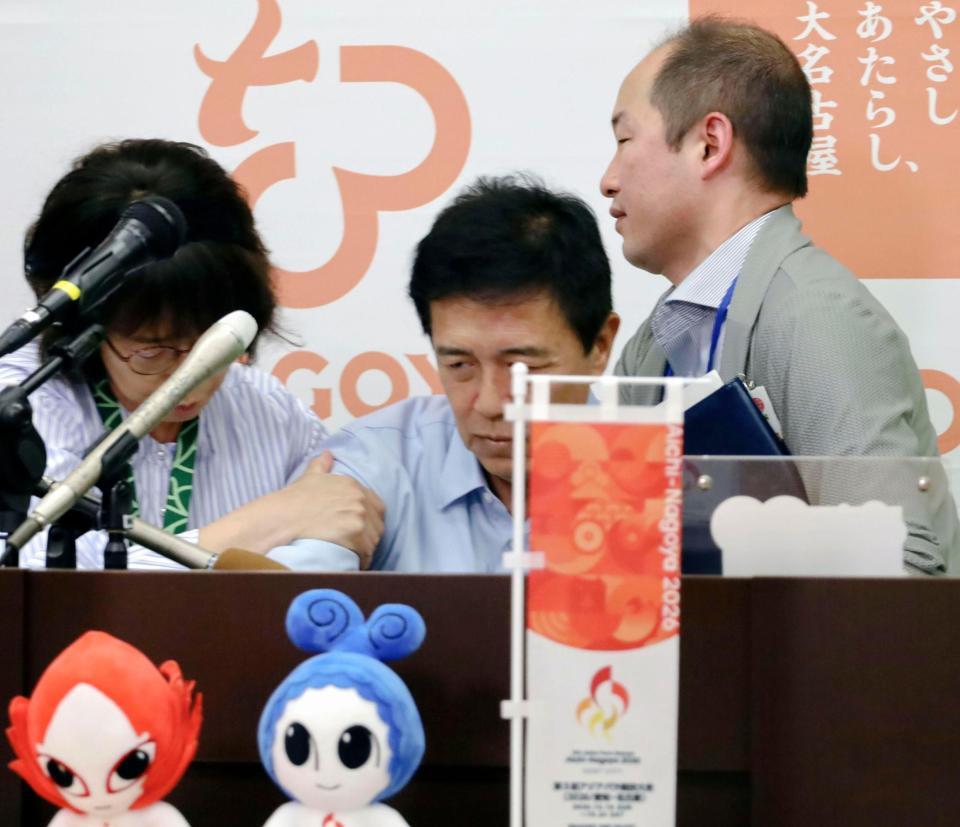 　名古屋市役所で行われた定例記者会見で、体調不良を訴え倒れ込む広沢一郎市長（中央）＝３０日午前１１時３１分