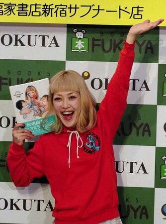 　長男、長女が写った本の表紙を持ちおどける松嶋尚美＝２０１５年