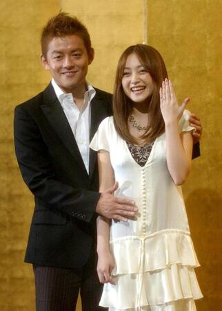 　夫の井戸田潤（左）からお腹をナデナデされ、はちきれんばかりの笑顔を見せる安達祐実（０５年９月１４日）