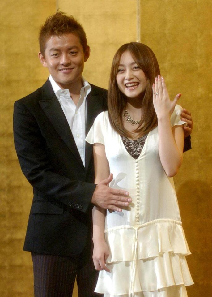 　夫の井戸田潤（左）からお腹をナデナデされ、はちきれんばかりの笑顔を見せる安達祐実（０５年９月１４日）