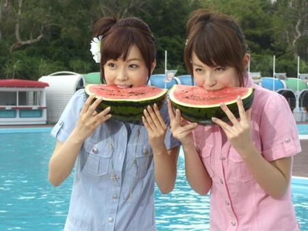 　プール開きでスイカをほおばる（左から）本田朋子アナ、平井理央アナ＝２００９年７月