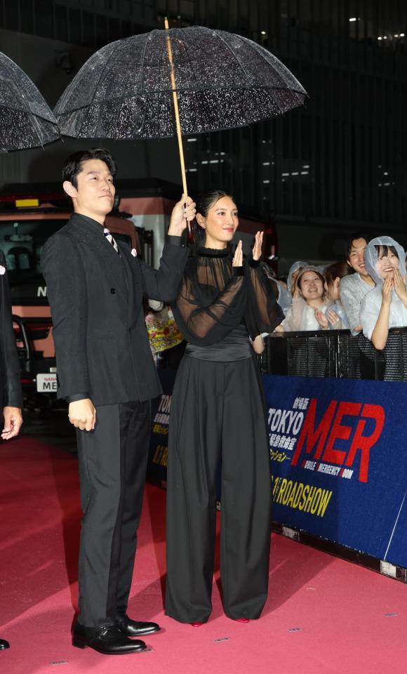 　雨の吹き込む中笑顔の鈴木亮平、菜々緒（撮影・金田祐二）