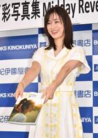 　写真集を手渡すポーズの上戸彩（撮影・持木克友）