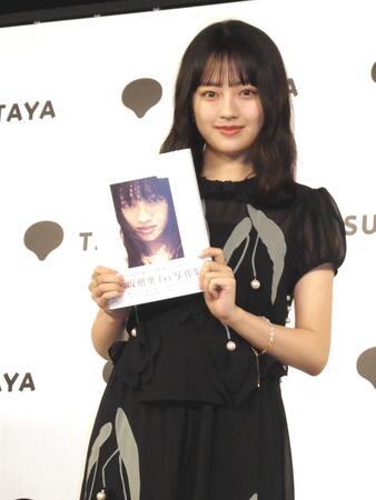 　写真集を笑顔で紹介する上坂樹里