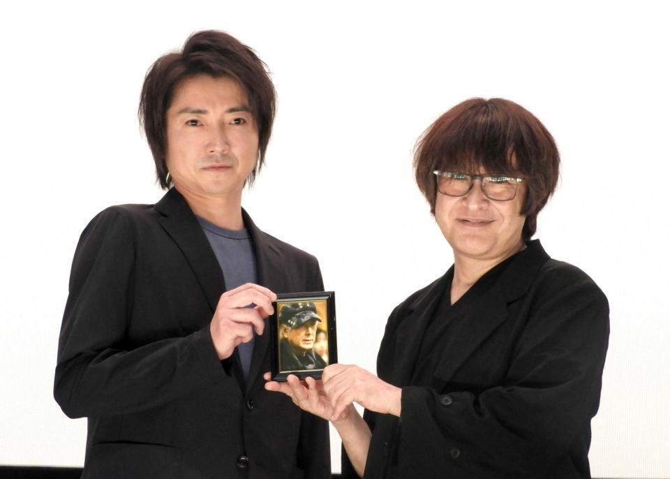 　深作欣二監督の遺影を持つ藤原竜也（左）と深作健太氏