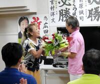 　母親の世津子さんからねぎらい花束を手渡される広田さくら氏