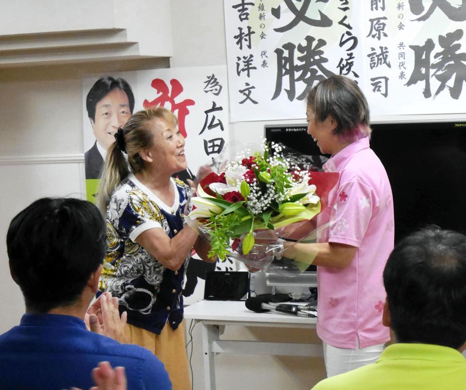 　母親の世津子さんからねぎらい花束を手渡される広田さくら氏