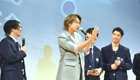 　映画「アオショー！」の完成披露試写会に登場し、指揮者の動きを披露する小山慶一郎（中央）