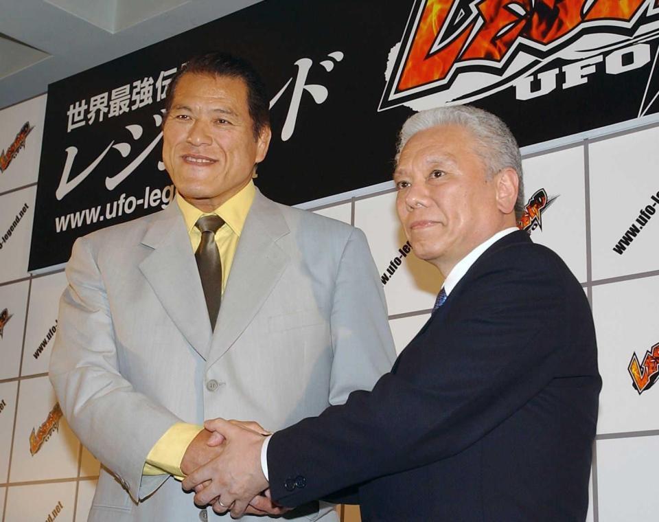 　格闘技イベントの会見で握手を交わす川村龍夫さん（右）とアントニオ猪木さん＝２００２年６月