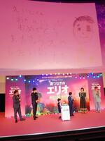 　「星つなぎのエリオ」の初日舞台あいさつで、７月２日に迎える川原瑛都（右から３人目）の１２歳の誕生日を祝う手紙（背景上）を送った佐藤大空（同４人目）。他に（左から）マユリカ中谷、松山ケンイチ、（右から）野呂佳代、清野菜名