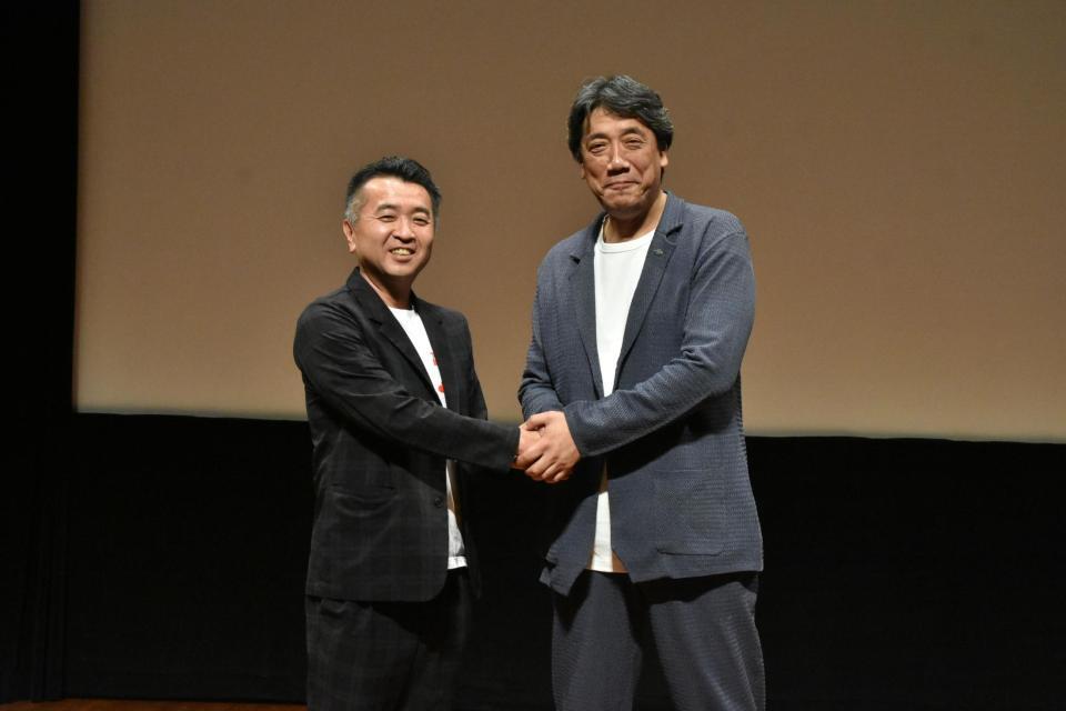 　「豊臣兄弟！」の松川博敬制作統括（左）と握手を交わす嶋尾康史