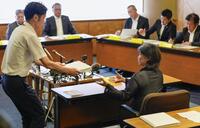 　静岡県伊東市議会の百条委員会で証人尋問に応じ、確認のために東洋大の卒業アルバムを受け取る田久保真紀市長（右）