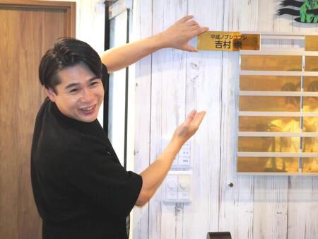 　ＶＩＰ会員第一号として、金の名札プレートを手に笑顔を見せる吉村崇