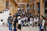 　大阪メトロ中央線が運転見合わせとなり、万博会場で座り込む人たち＝１３日