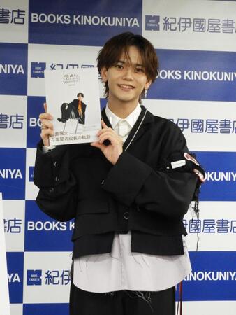 　書籍を手に笑顔を見せる中島颯太