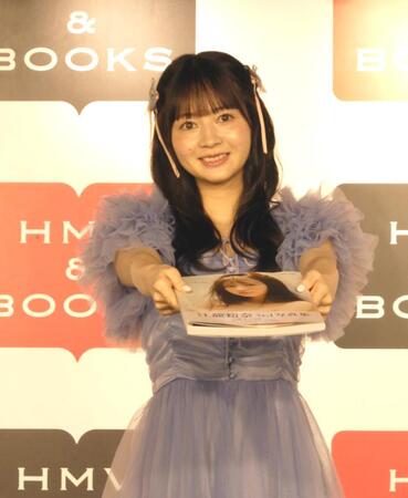 　写真集を渡すポーズをとる江籠裕奈
