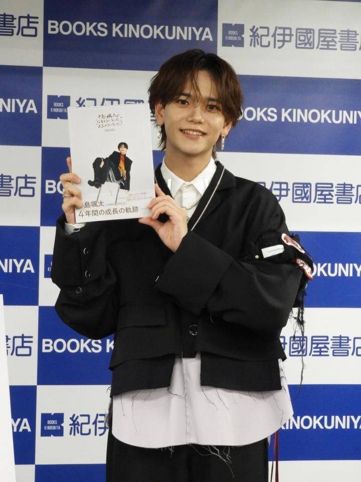 　書籍を手に笑顔を見せる中島颯太