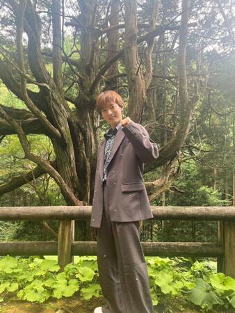 　樹高３２メートルを誇る「大久保のヒノキ」を背景に撮影に応じた青山新＝宮崎・椎葉村