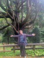 　天然記念物「大久保の大ヒノキ」の前でポーズを決める青山新