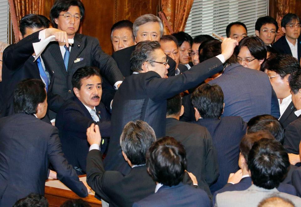 　２０１５年９月、安保関連法案の強行採決で、委員長席に着いた自民党の佐藤正久氏（中央左）に詰め寄る野党議員ら