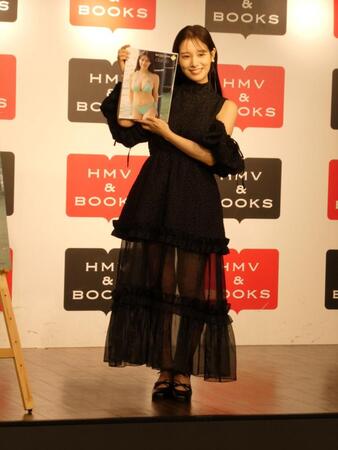 　写真集を持って撮影に応じる葉月くれあ