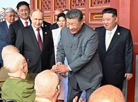 　天安門の楼上で、退役軍人らと握手を交わす中国の習近平国家主席（右から２人目）。右端は北朝鮮の金正恩朝鮮労働党総書記。左から３人目はロシアのプーチン大統領（新華社＝共同）