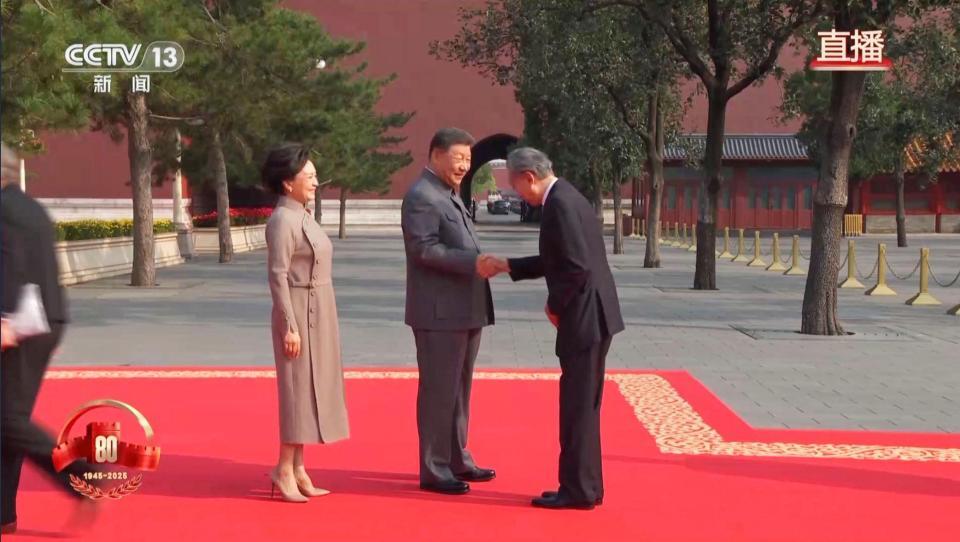 　抗日戦争勝利80年記念行事を前に中国の習近平国家主席（中央）の出迎えを受ける鳩山由紀夫元首相（右）。中国国営中央テレビが３日放映した（同テレビの電子版から、共同）