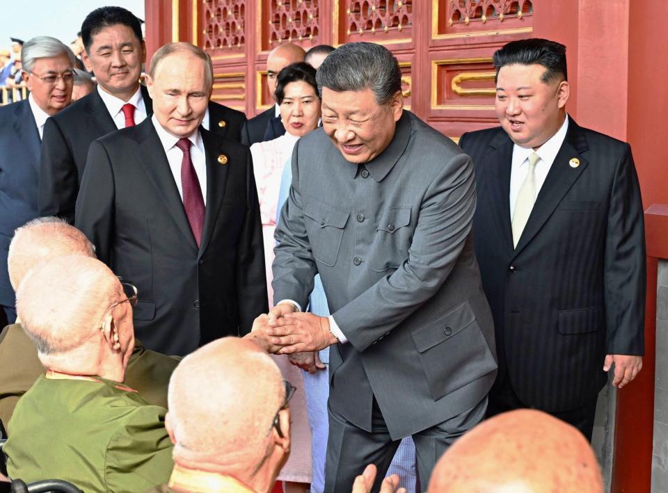 　天安門の楼上で、退役軍人らと握手を交わす中国の習近平国家主席（右から２人目）。右端は北朝鮮の金正恩朝鮮労働党総書記。左から３人目はロシアのプーチン大統領（新華社＝共同）