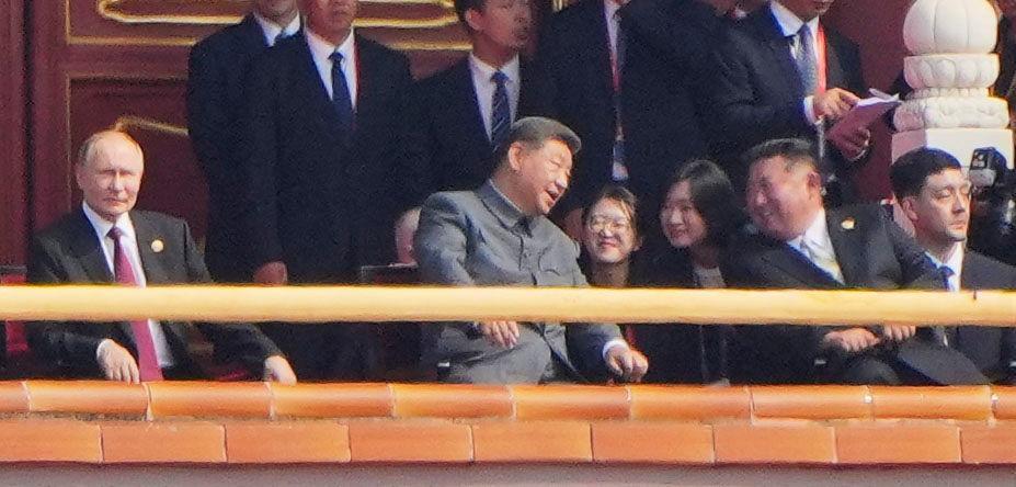 　抗日戦争勝利80年記念行事に出席し北朝鮮の金正恩朝鮮労働党総書記（右）と言葉を交わす中国の習近平国家主席。左はロシアのプーチン大統領＝北京の天安門（共同）