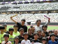 　バトンを掲げる（左奧の）高平慎士さん、（右奥の）織田裕二